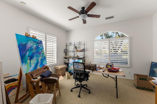 carpeted home office featuring ceiling fan