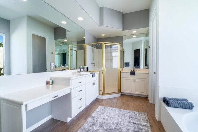 bathroom featuring hardwood / wood-style flooring, vanity, and shower with separate bathtub