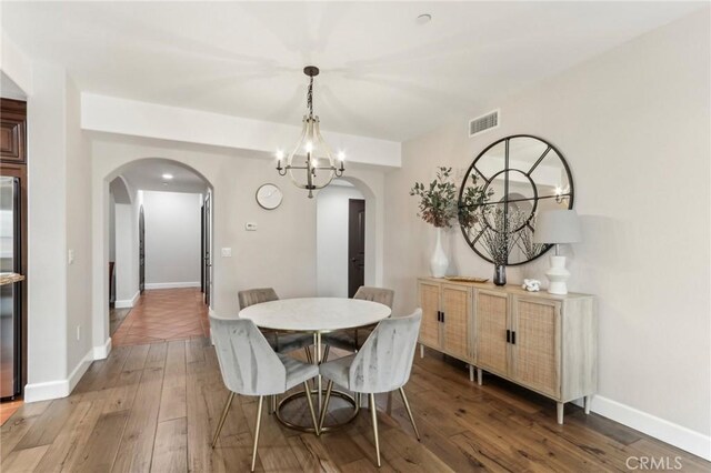 dining area with an inviting chandelier and dark hardwood / wood-style flooring