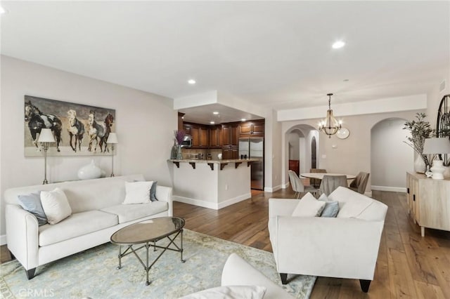 living room featuring a notable chandelier and light wood-type flooring