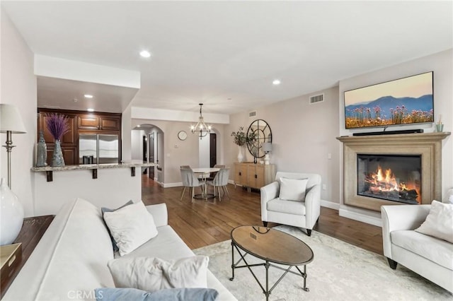 living room featuring a chandelier and light hardwood / wood-style flooring