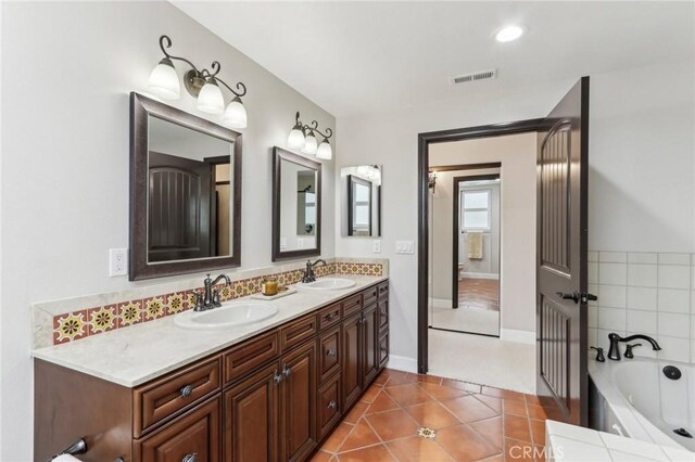 bathroom with vanity, a bath, and tile patterned floors