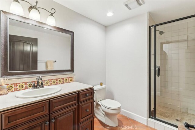 bathroom featuring walk in shower, vanity, toilet, and tile patterned flooring