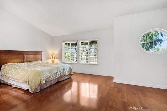 bedroom featuring hardwood / wood-style flooring and lofted ceiling