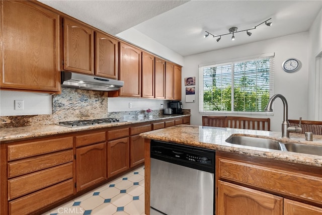 kitchen featuring light stone counters, sink, backsplash, and appliances with stainless steel finishes