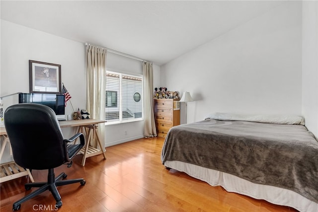 bedroom featuring lofted ceiling and wood-type flooring