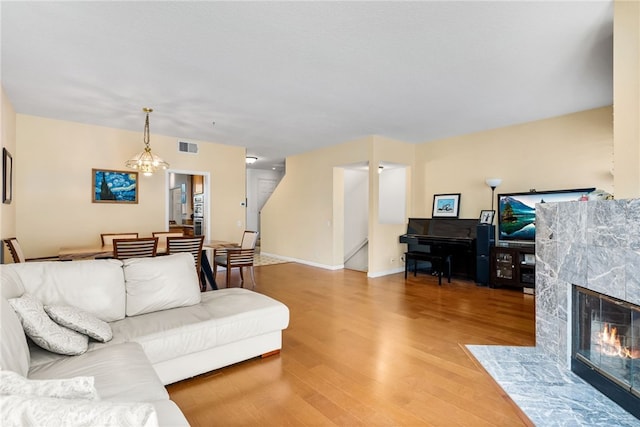 living room with a tile fireplace, hardwood / wood-style floors, and an inviting chandelier