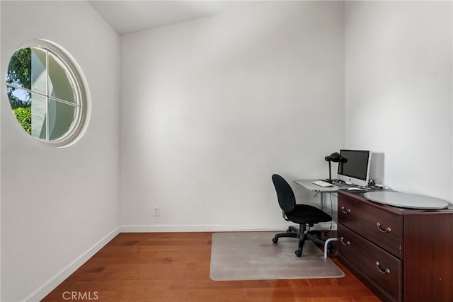 home office with light hardwood / wood-style flooring