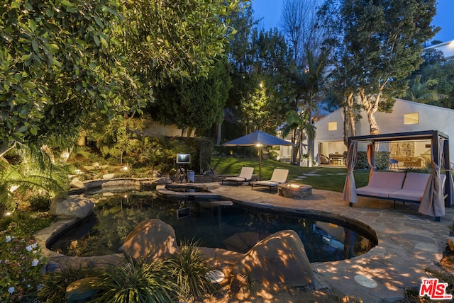 view of swimming pool with an outdoor living space with a fire pit and a patio