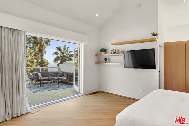 bedroom featuring lofted ceiling, access to outside, and light hardwood / wood-style floors