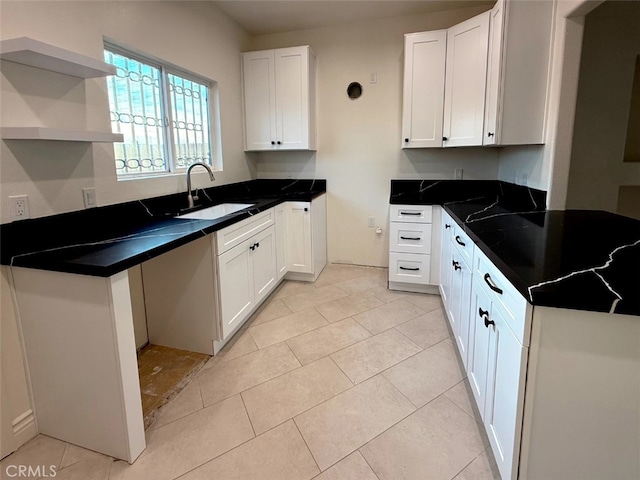 kitchen featuring white cabinetry, sink, and light tile patterned flooring