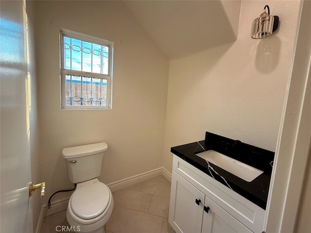 bathroom featuring tile patterned flooring, vaulted ceiling, vanity, and toilet