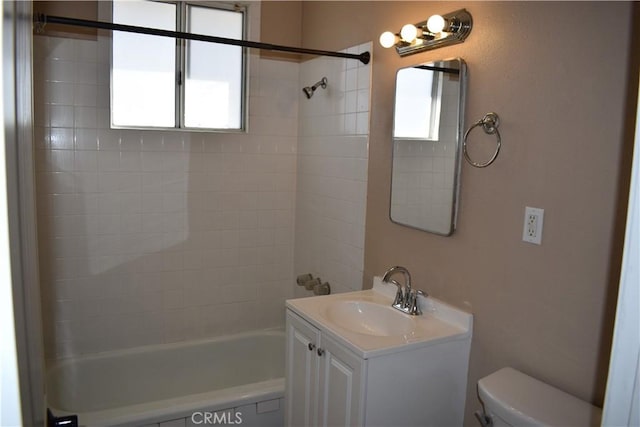 full bathroom with vanity, plenty of natural light, tiled shower / bath, and toilet