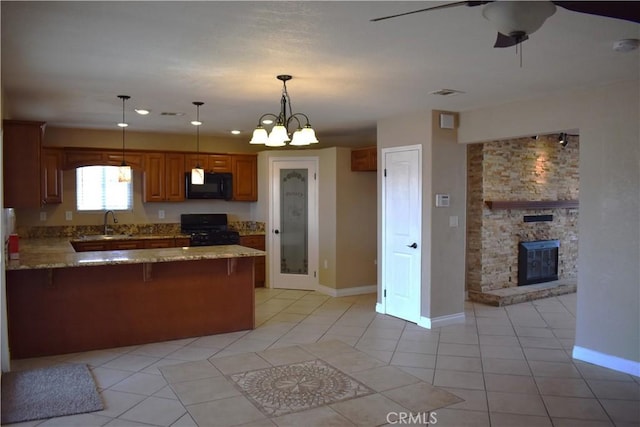 kitchen featuring decorative light fixtures, black appliances, kitchen peninsula, and light tile patterned flooring