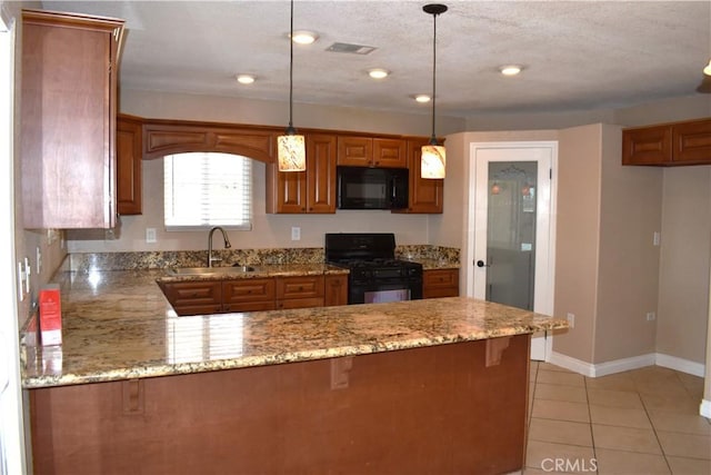 kitchen featuring pendant lighting, sink, black appliances, light stone countertops, and kitchen peninsula