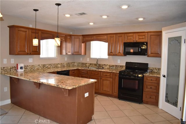 kitchen with pendant lighting, sink, a wealth of natural light, black appliances, and kitchen peninsula