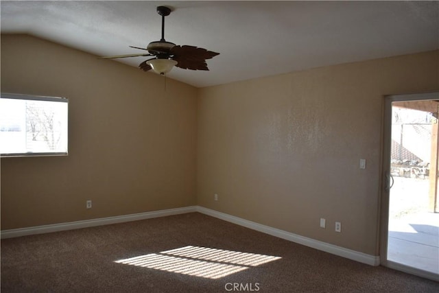 carpeted spare room featuring vaulted ceiling and ceiling fan