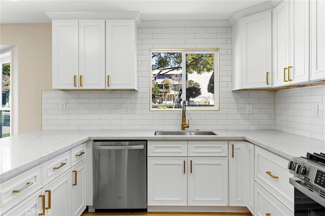 kitchen with appliances with stainless steel finishes, sink, white cabinets, and decorative backsplash