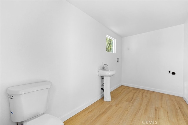 bathroom featuring wood-type flooring, sink, and toilet