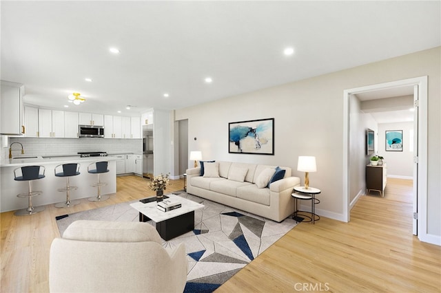 living room featuring sink and light wood-type flooring