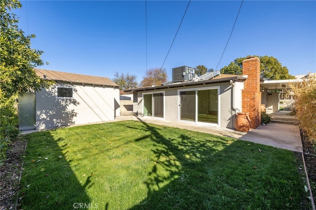 back of house featuring cooling unit, a lawn, a patio, and solar panels