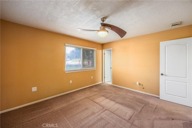 unfurnished room with ceiling fan, carpet flooring, and a textured ceiling