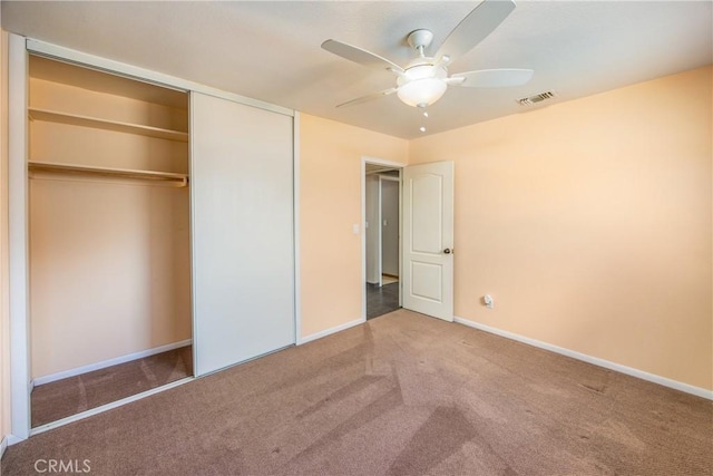 unfurnished bedroom with ceiling fan, a closet, and carpet