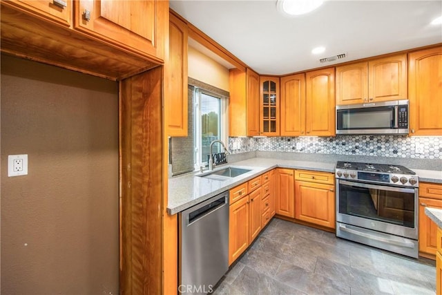 kitchen with appliances with stainless steel finishes, sink, and backsplash