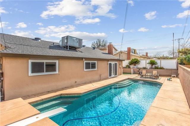 view of pool featuring central AC, a diving board, and a patio