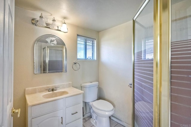 bathroom with vanity, a shower with shower door, tile patterned floors, and toilet