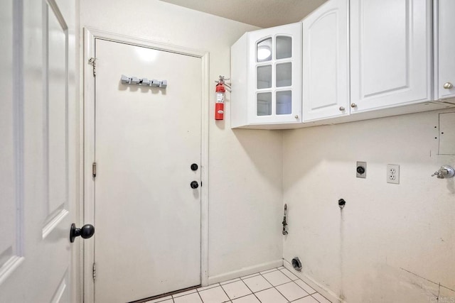 laundry area featuring light tile patterned flooring, cabinets, and hookup for an electric dryer