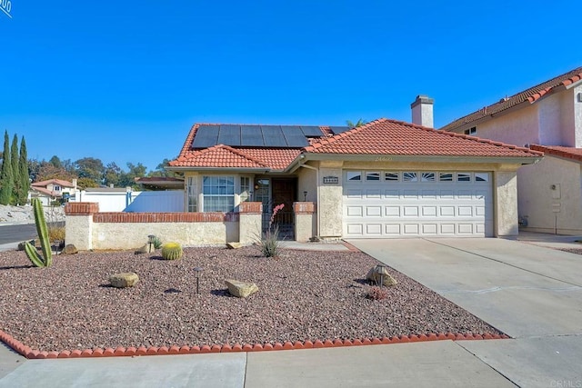 view of front of property with a garage and solar panels