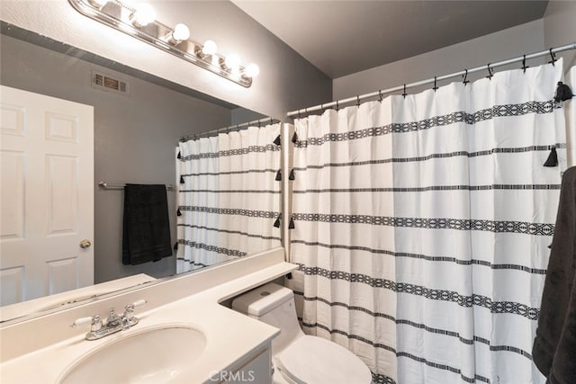 bathroom featuring vanity, curtained shower, and toilet