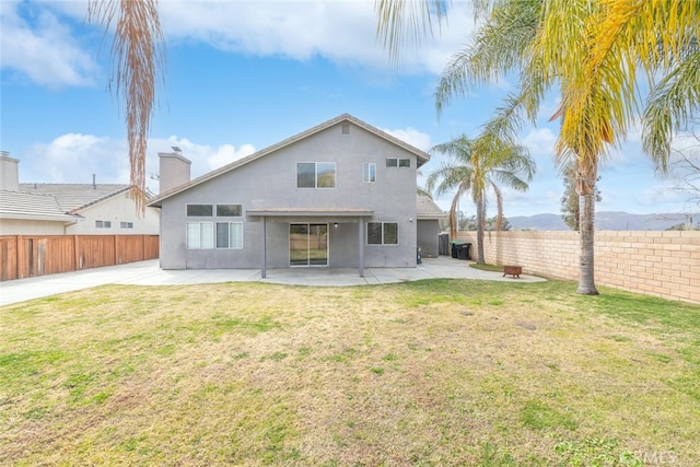 back of house with a lawn and a patio