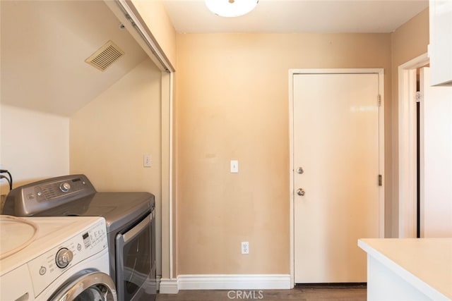 washroom with dark wood-type flooring and washing machine and dryer