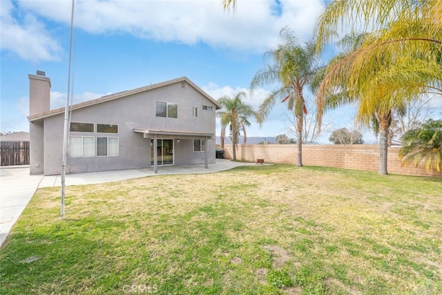 back of property featuring a yard and a patio area