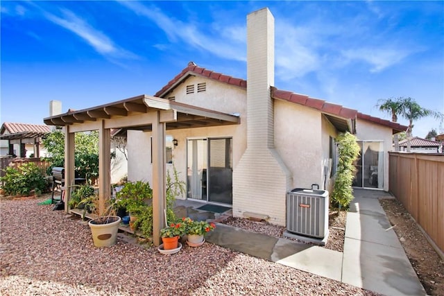 rear view of house featuring central AC unit and a patio area