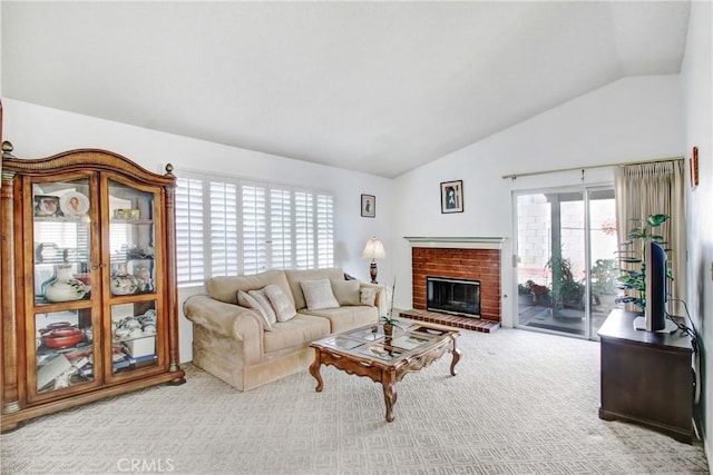 living room featuring vaulted ceiling, carpet floors, and a fireplace