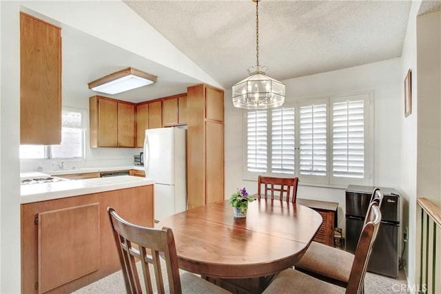 dining area featuring sink, vaulted ceiling, and a chandelier