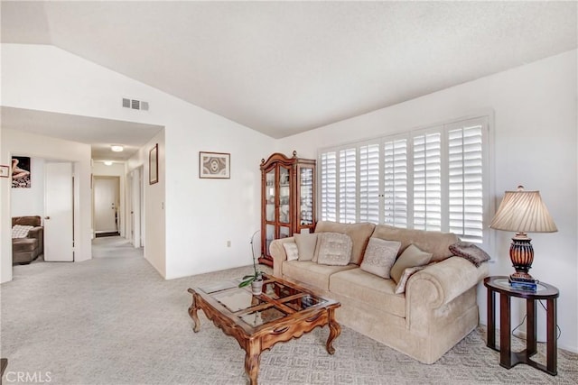 carpeted living room with vaulted ceiling