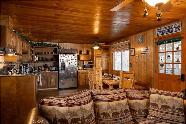 dining room featuring ceiling fan, wooden walls, and wooden ceiling