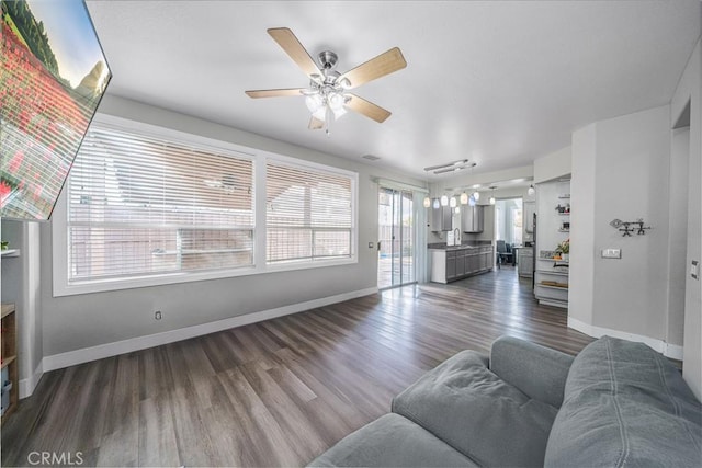 living room with dark wood-type flooring and ceiling fan