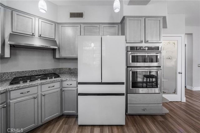 kitchen with pendant lighting, appliances with stainless steel finishes, dark hardwood / wood-style floors, and gray cabinetry