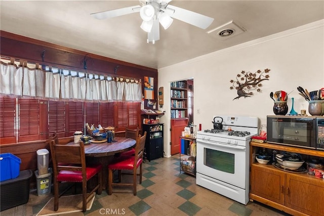 kitchen featuring ornamental molding, gas range gas stove, and ceiling fan