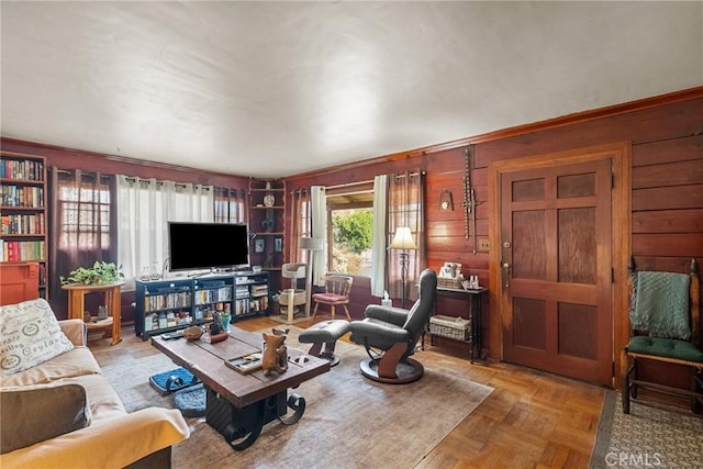 living room with light parquet flooring and wood walls