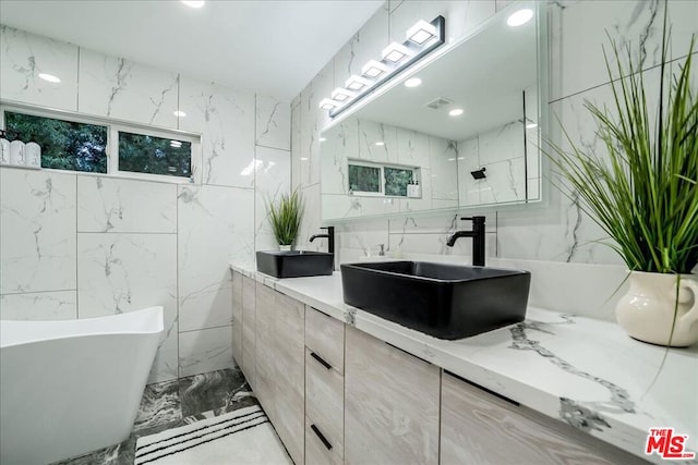 bathroom featuring vanity, tile walls, and a bathing tub