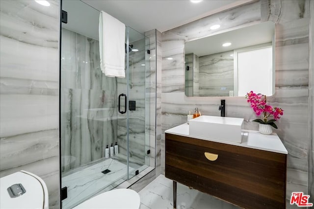 bathroom featuring a shower with door, vanity, and toilet