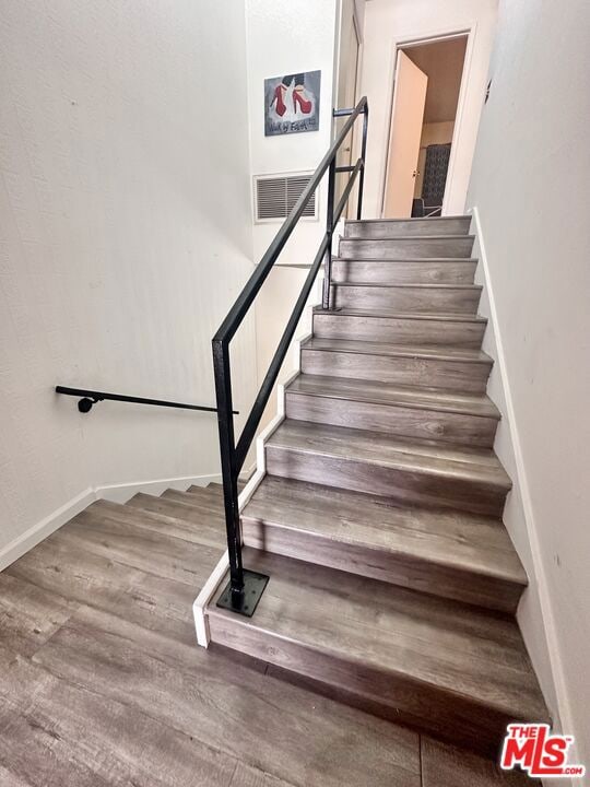 stairs featuring wood-type flooring