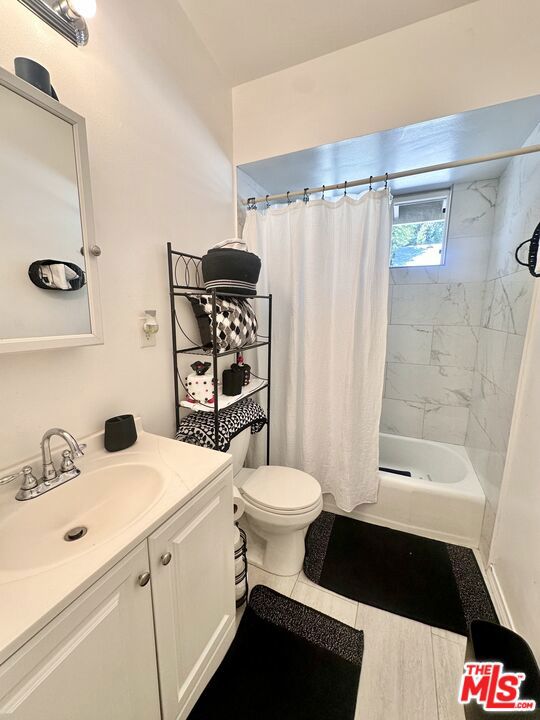 full bathroom with vanity, shower / tub combo, tile patterned floors, and toilet