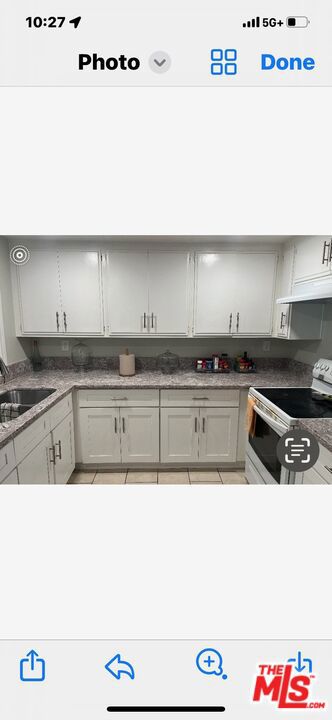 kitchen featuring sink, light tile patterned floors, and electric range